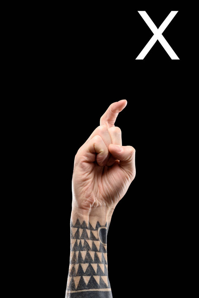 main tatouée montrant la lettre cyrillique, langue des signes, isolé sur noir
 - Photo, image