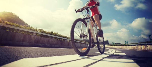 Νέοι γυναίκα ποδηλάτης ιππασίας ποδήλατο βουνού στον αυτοκινητόδρομο - Φωτογραφία, εικόνα