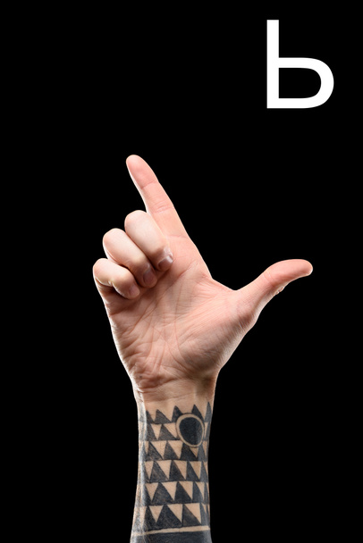 male tattooed hand showing cyrillic letter, sign language, isolated on black - Photo, Image