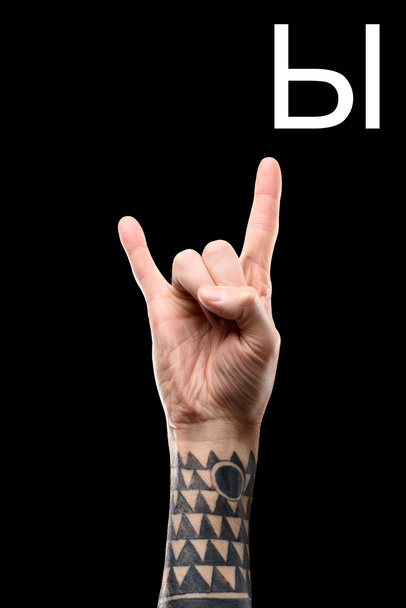 cropped view of male tattooed hand showing cyrillic letter, deaf and dumb language, isolated on black - Foto, afbeelding