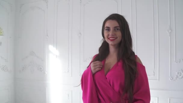 Cute woman in a beautiful pink dress on a white background. - Metraje, vídeo