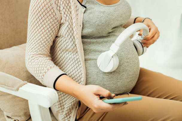 Pregnant woman creating a playlist for her future baby - Foto, afbeelding