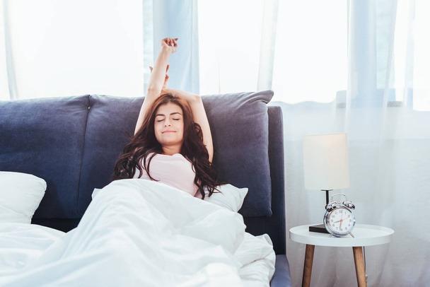 csinos, fiatal nő, stretching ágy az időszakban reggel otthon - Fotó, kép