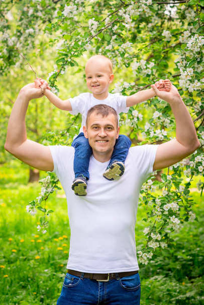 Szczęśliwy ojciec z synem młodych w parku na spacer - Zdjęcie, obraz