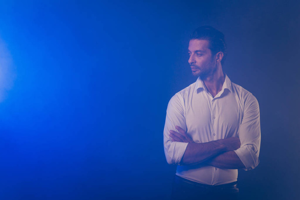 Portrait of nice chic classy elegant attractive handsome confident man in white shirt folded arms looking aside copy empty blank space isolated over dark blue fume smoke background - Φωτογραφία, εικόνα