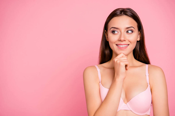 Close up portrait of brunette dreamy cute gorgeous gentle  touching chin looking with interest to copyspace her she girl wearing pale pink bra isolated on rose background - Foto, Imagem