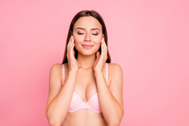 Close up portrait of happy tender cute gorgeous touching soft facial skin her she girl wearing pale pink bra isolated on rose background - Foto, afbeelding