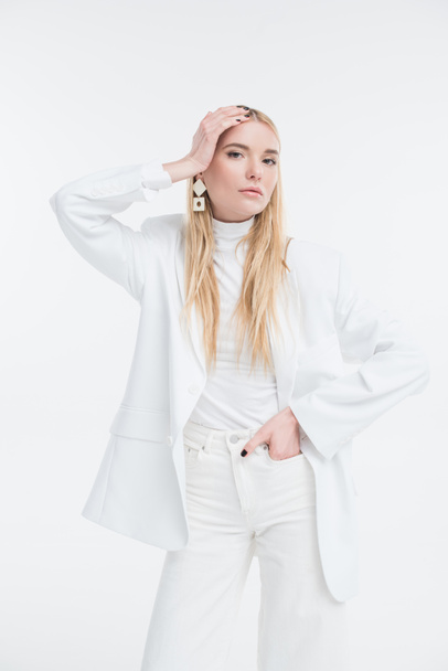 attractive caucasian blonde woman in fashionable white clothes touching head and posing isolated on white - Photo, Image