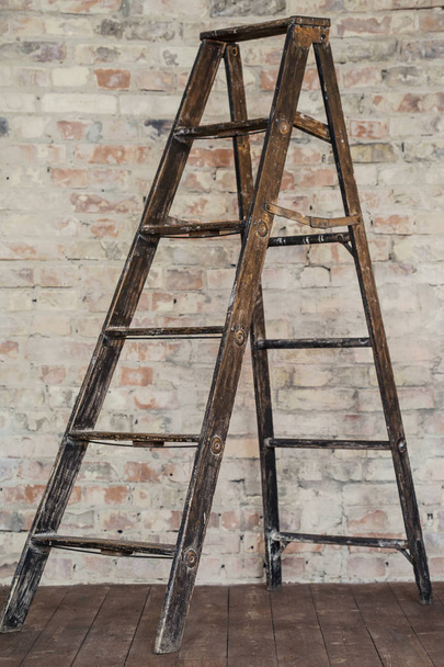 ξύλινη σκάλα σε φόντο τοίχο τούβλου. Παλιά σκάλα - Φωτογραφία, εικόνα