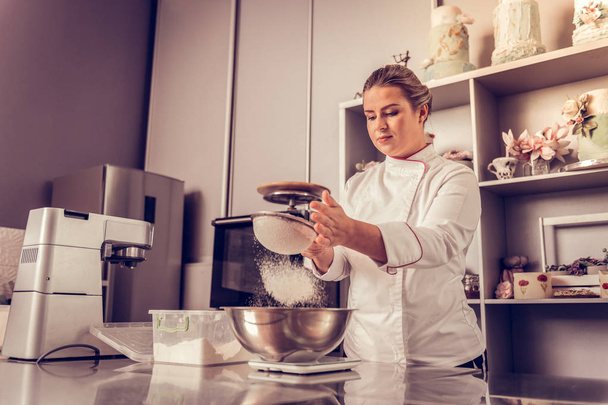 Pleasant skilled woman preparing a tasty cake - Fotoğraf, Görsel