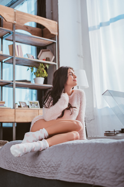 happy girl sitting on bed and listening vinyl audio player at home - Φωτογραφία, εικόνα