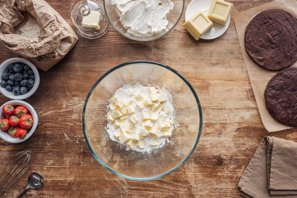 vista superior del tazón con harina y mantequilla e ingredientes para pastel casero en la mesa
  - Foto, Imagen