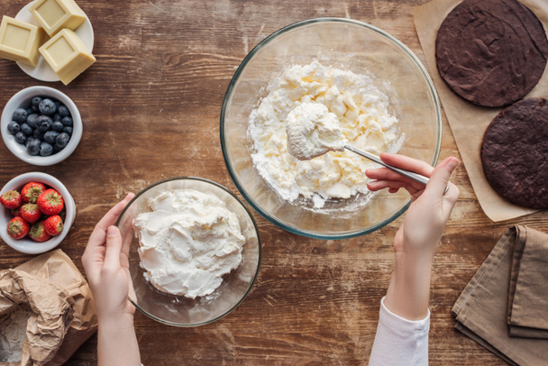 おいしいケーキの生地とクリームを準備する女性のショットをトリミング  - 写真・画像
