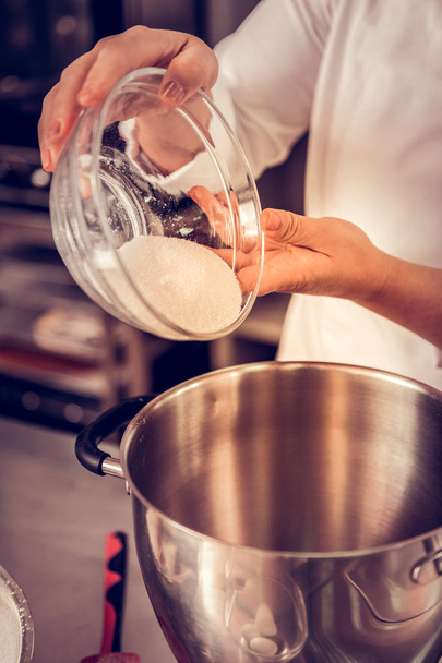 Close up of sugar being poured into the bowl - Foto, afbeelding