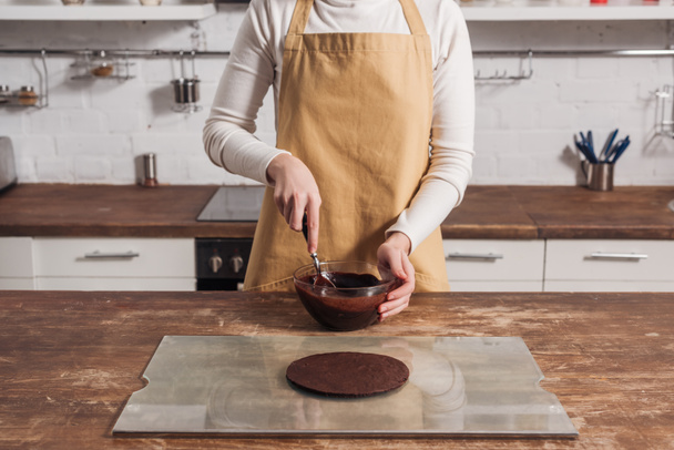 середня частина жінки в фартусі готує тісто для смачного торта на кухні
   - Фото, зображення