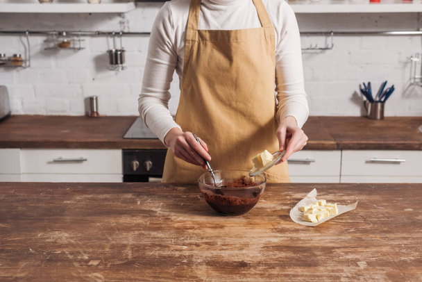 cropped shot of woman in apron preparing dough for delicious cake in kitchen   - Foto, Bild
