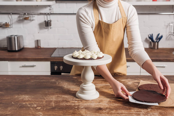 partial view of woman in apron cooking delicious whoopie pie cake - Foto, afbeelding