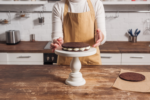 mid section of woman in apron preparing gourmet whoopie pie cake in kitchen   - Фото, изображение