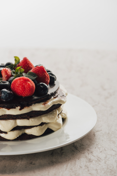 lahodné prdící koláčový dort s čerstvým ovocem na bílé plotně - Fotografie, Obrázek
