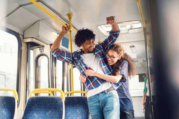 Молодой счастливый мужчина и женщина обнимаются в автобусе
 - Фото, изображение