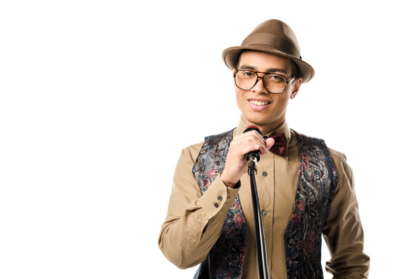 hymyilevä sekoitettu rodun mies tyylikäs hattu ja silmälasit laulaa mikrofonissa eristetty valkoinen
 - Valokuva, kuva
