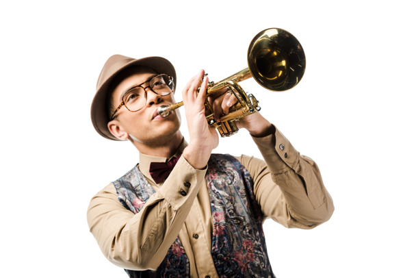 Junge gemischte Rasse Mann mit stylischem Hut und Brille spielt auf Trompete isoliert auf weiß  - Foto, Bild