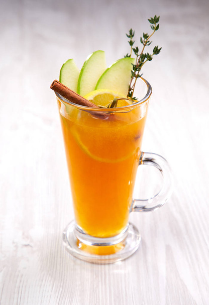 χειμώνα τσάι με μήλο σε ποτήρι σε ξύλινα φόντο, γκρο πλαν  - Φωτογραφία, εικόνα