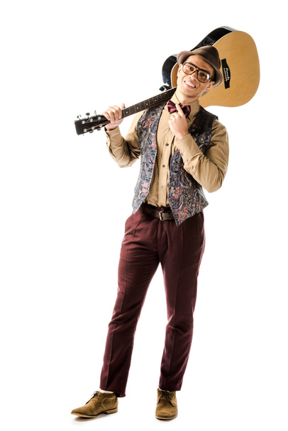 sonriente músico masculino con sombrero y gafas posando con guitarra acústica aislada en blanco
 - Foto, Imagen