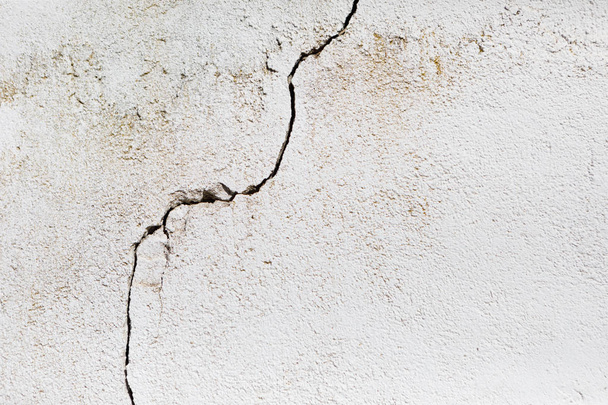 Barst in een witte muur met cement baksteen oppervlak - Foto, afbeelding