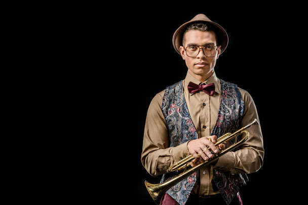 стильний молодий чоловічий музикант позує з трубою ізольовано на чорному
 - Фото, зображення
