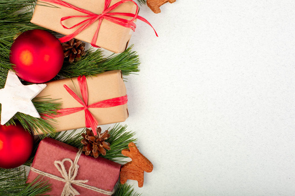 Weihnachtskomposition. weiße Weihnachtsdekoration, Tannenzweige mit Spielzeug-Geschenkschachteln auf weißem Hintergrund. flache Lage, Draufsicht, Kopierraum, Grußkarte - Foto, Bild