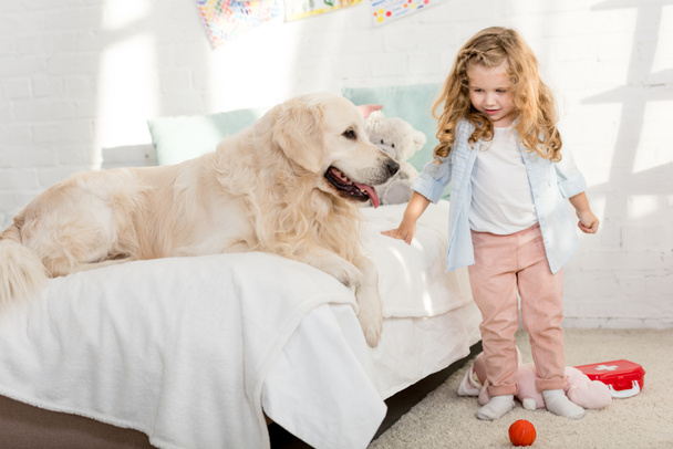imádnivaló kid közelében gyermekek szobában kutya ágy - Fotó, kép