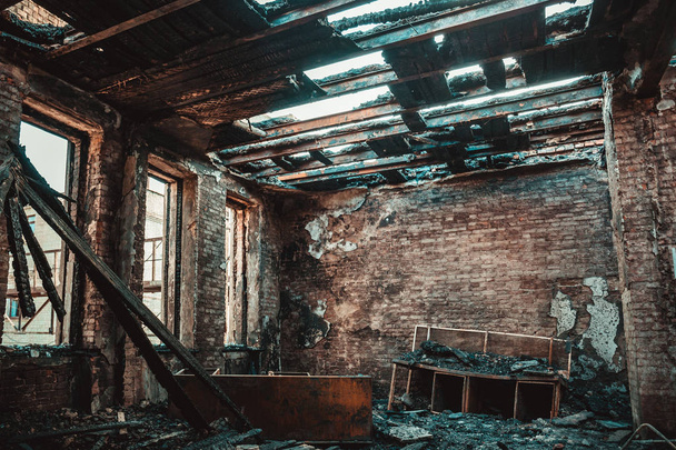 Casa de tijolo queimado interior com móveis queimados, sala de construção arruinada após o fogo dentro
 - Foto, Imagem
