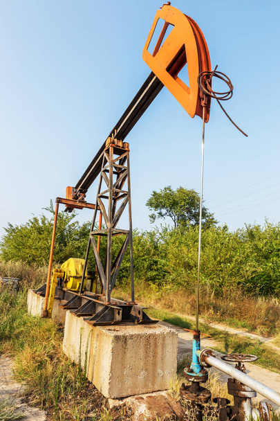 Pieni yksityinen öljynporaustorni pumppaa öljyä kentälle. Vanha käsityö öljynporauslautan taustalla luovan teollisen muotoilun. Mineraalien laiton kehittäminen. Bulgaria Tyulenovo, 2016
 - Valokuva, kuva