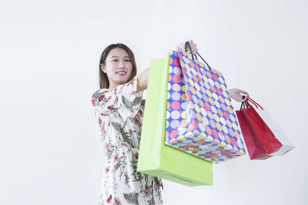 junge Frau hält Einkaufstüten in der Hand und lächelt in die Kamera - Foto, Bild