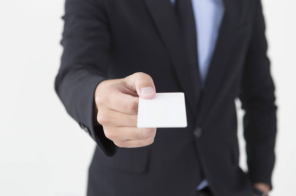 Young man in a suit showing his business card to the camera - Photo, Image