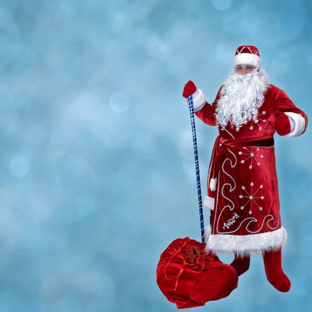 Santa Clause s pytlem dárků na modrém pozadí - Fotografie, Obrázek