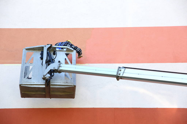 Painting the facade from at a height using a special jib. - Foto, Imagen