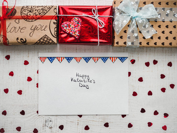 Happy Valentine's Day. Bright gift boxes tied with a ribbon, a note with sweet words about love and confetti. Closeup, flat lay. Congratulations for loved ones, relatives, friends and colleagues - Foto, Imagem