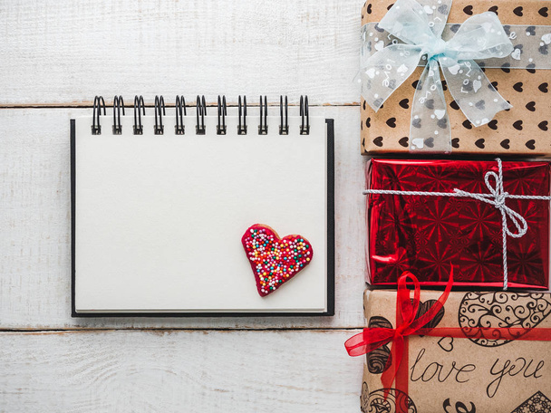 Blank Notepad Page for sweet words about love, bright gift boxes and confetti on a wooden white surface of the boards. Closeup, flat lay. Congratulations for loved ones, relatives, friends, colleagues - Foto, Imagem