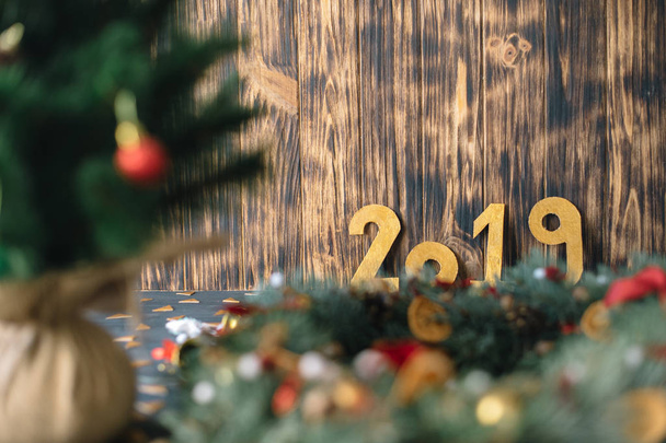 The inscription 2019 on the background of New Year's decorations on a wooden background - Valokuva, kuva