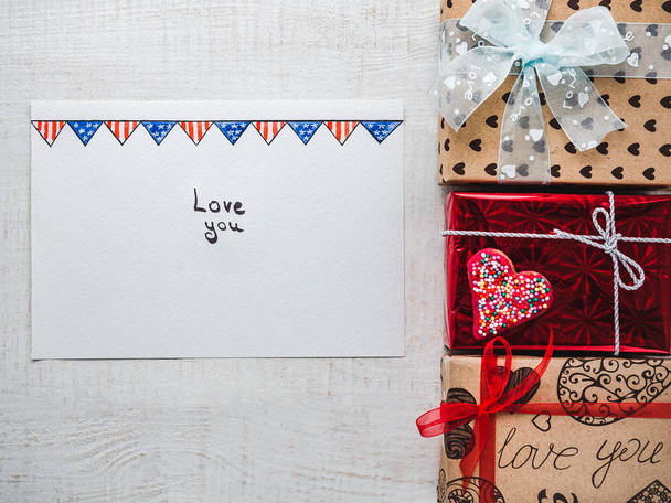 Blank Notepad Page for sweet words about love and bright gift boxes on a wooden white boards. Closeup, flat lay. Congratulations for loved ones, relatives, friends, colleagues - Foto, Bild