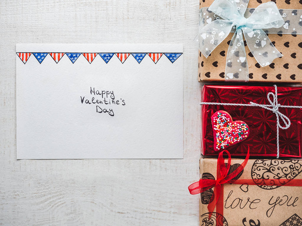 Happy Valentine's Day. Bright gift boxes tied with a ribbon, a note with sweet words about love and confetti. Closeup, flat lay. Congratulations for loved ones, relatives, friends and colleagues - Фото, изображение