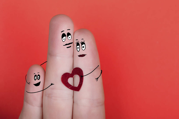 happy family of fingers with painted faces on red background - Photo, Image