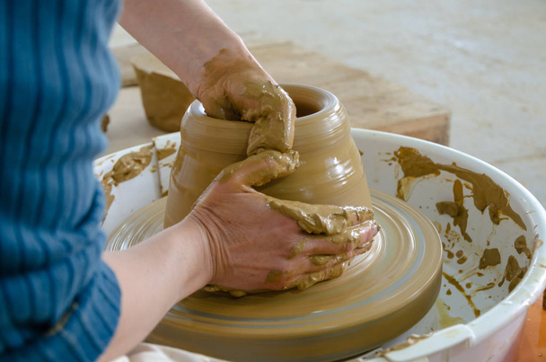 Yakın çekim yakışıklı kadın Potter Clay, seçici odak bir vazo yapma önlük - Fotoğraf, Görsel
