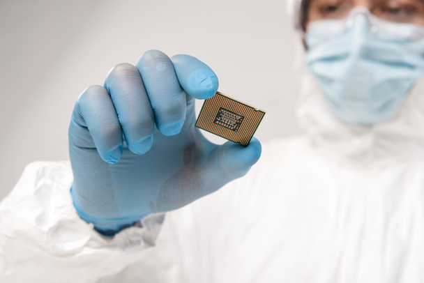 selective focus of microchip in hand of scientist wearing latex glove on grey background - Photo, Image