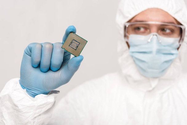 selective focus of microchip in hand of scientist in googles isolated on grey  - Photo, Image