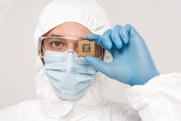 scientist in googles holding microchip in hand isolated on grey  - Photo, Image