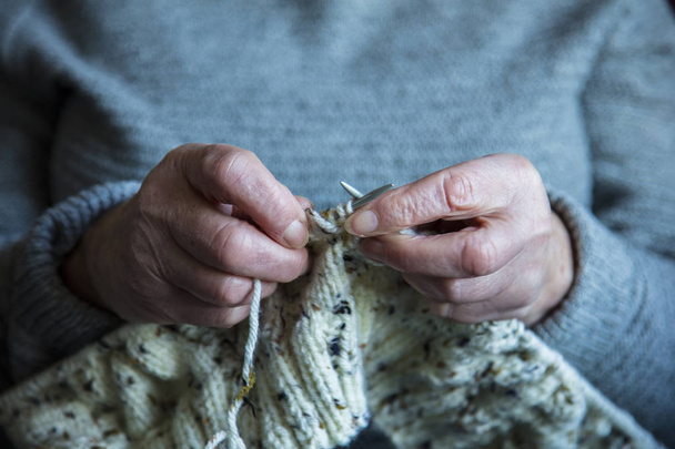 Close up of an older womens hands knitting a jumper - Fotoğraf, Görsel