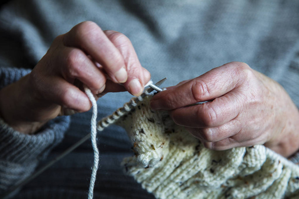 Close up of an older womens hands knitting a jumper - Foto, Imagem